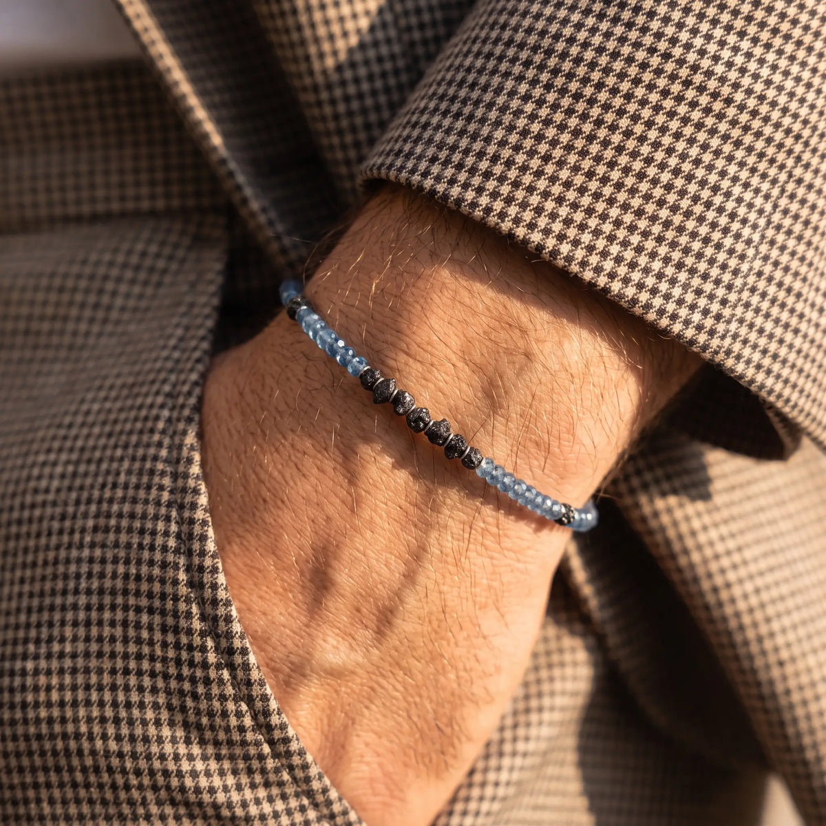 Raw Black Diamond - Aquamarine Bracelet I (4mm), with blue faceted beads and rough black diamonds, worn beside a brown houndstooth sleeve.