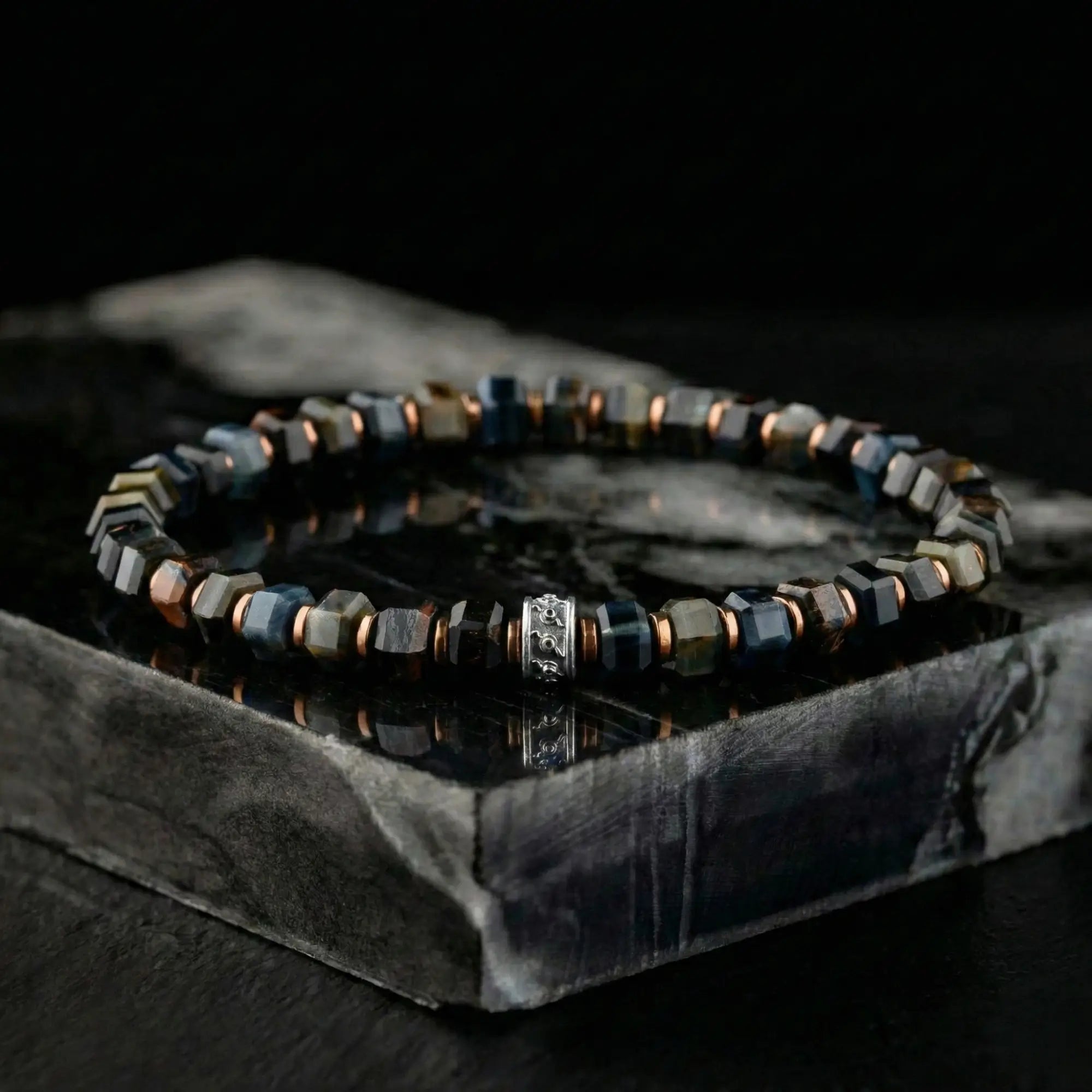 Blue tiger eye bracelet for men on stone setting, lifestyle view. 6mm Hawk's Eye design. Aurum Brothers.