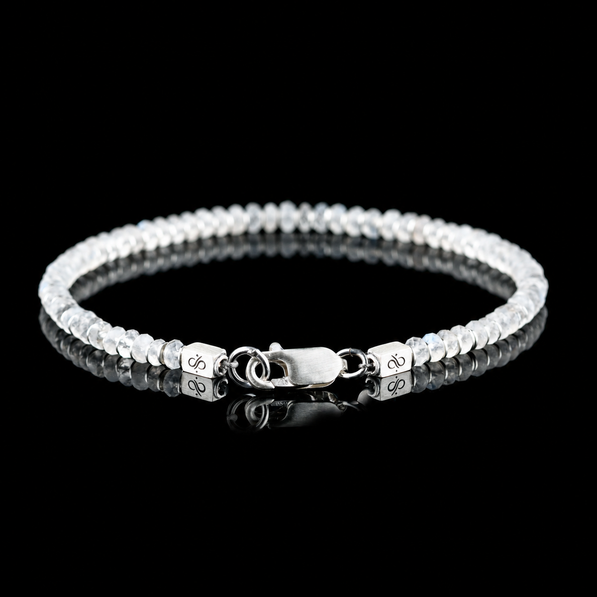 Back view of Moonstone Bracelet X (4mm), showing the clasp and branded end pieces on a black reflective surface.
